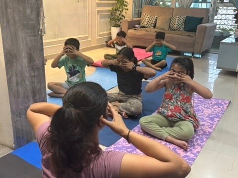 Kids practicing Bhramari pranayama in yoga class